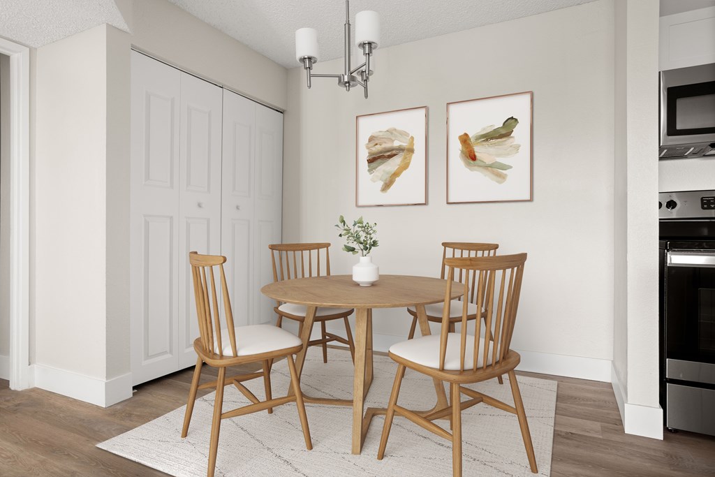 a dining room with a table and chairs and two paintings on the wall